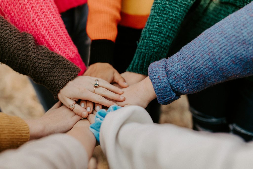Women's hands all in, symbolizing a team spirit.